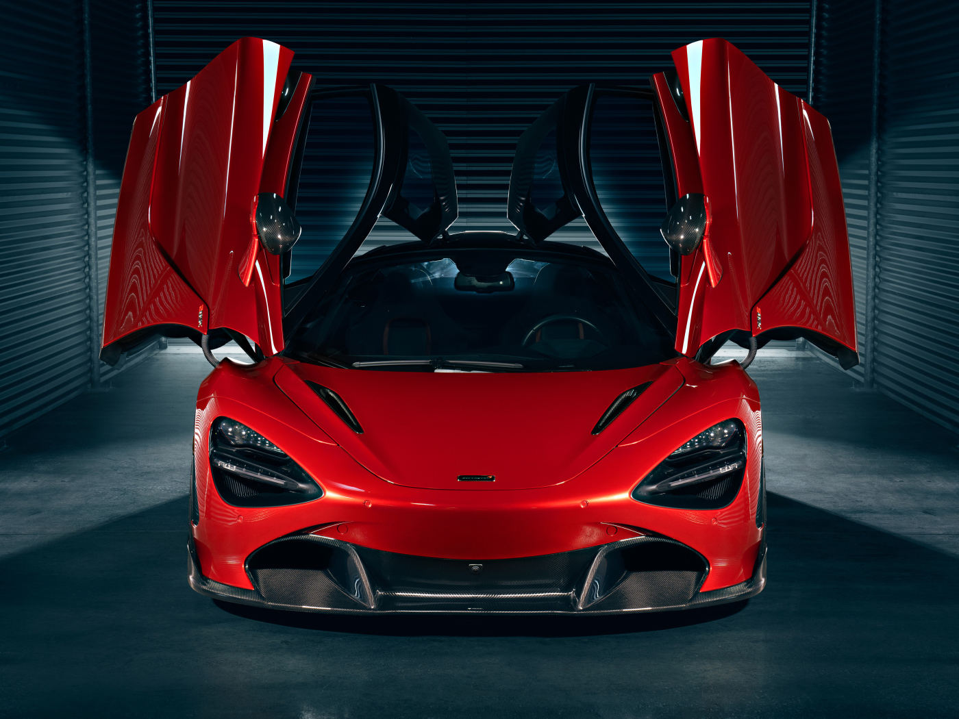 Красный автомобиль McLaren 720S с открытыми дверями в гараже