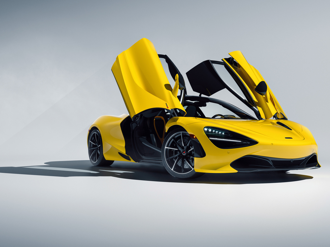 Желтый автомобиль McLaren 720S CGI с открытыми дверями на сером фоне