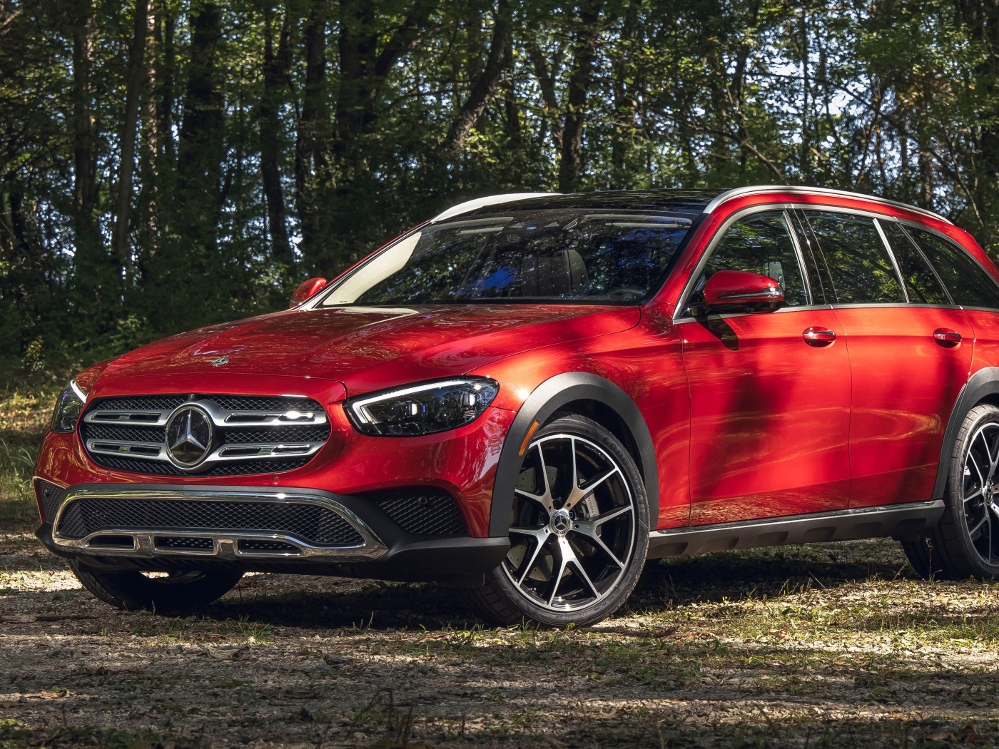 Красный автомобиль Mercedes-Benz E 450 4MATIC, 2021 года в лесу
