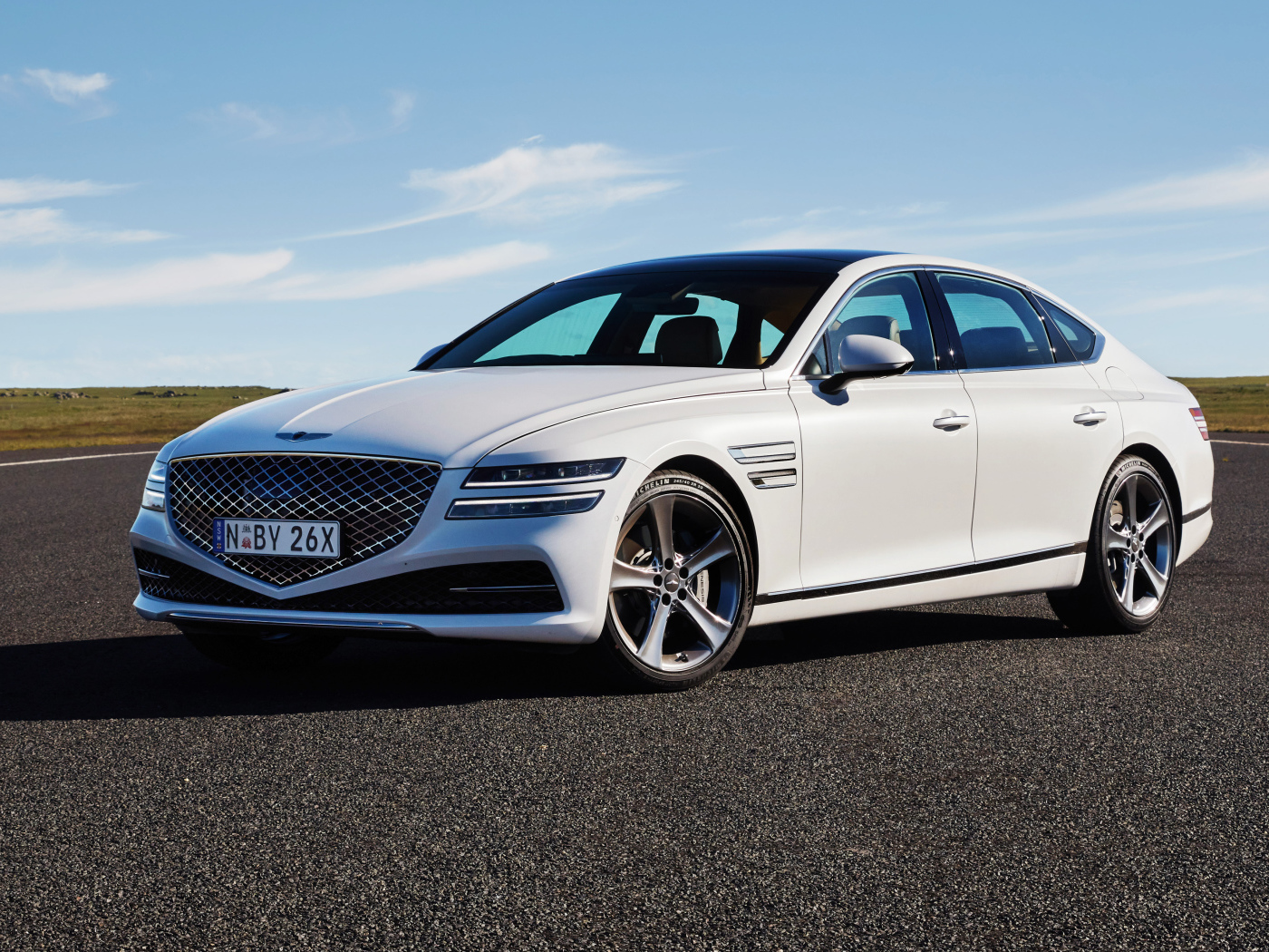 Белый автомобиль Genesis G80 3.5T AWD 2020 года на трассе