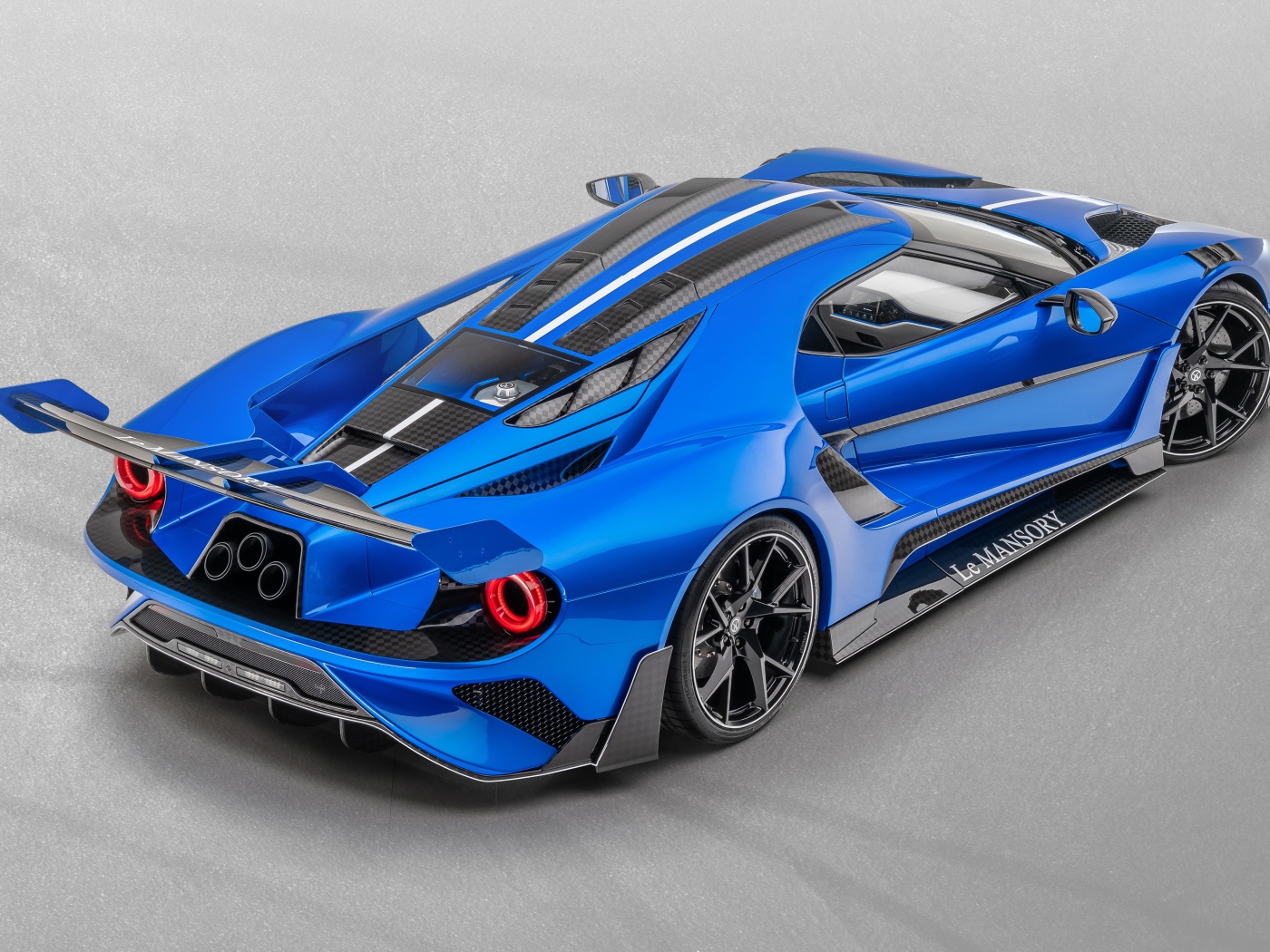 Синий автомобиль Mansory La MANSORY 2020 года на сером фоне вид сзади