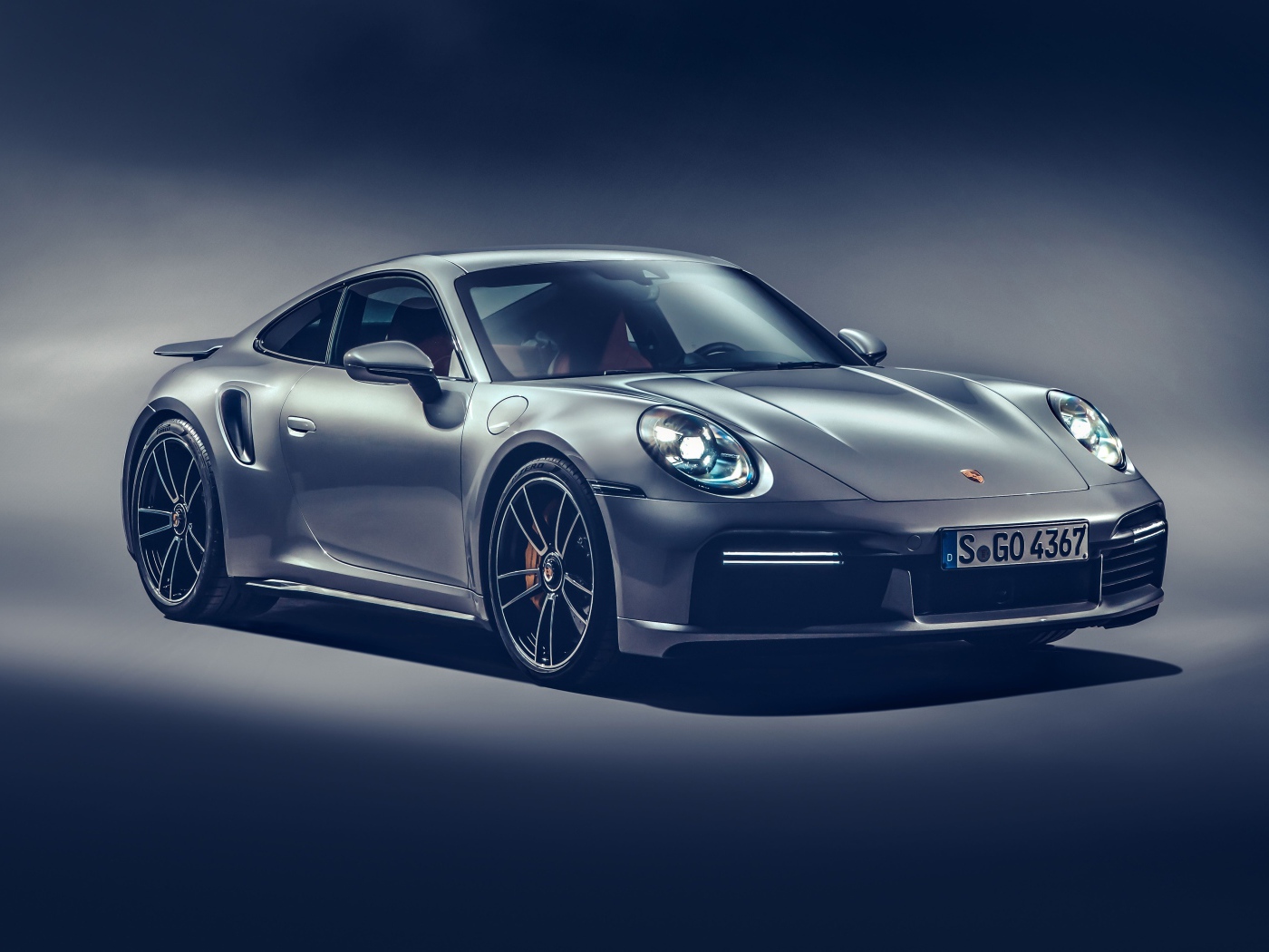 Автомобиль Porsche 911 Turbo S 2020 года на сером фоне