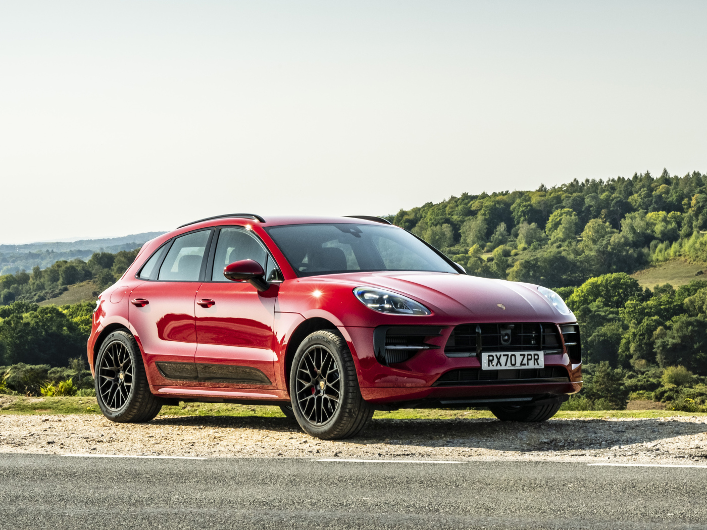Красный автомобиль Porsche Macan GTS 2020  года в лучах солнца