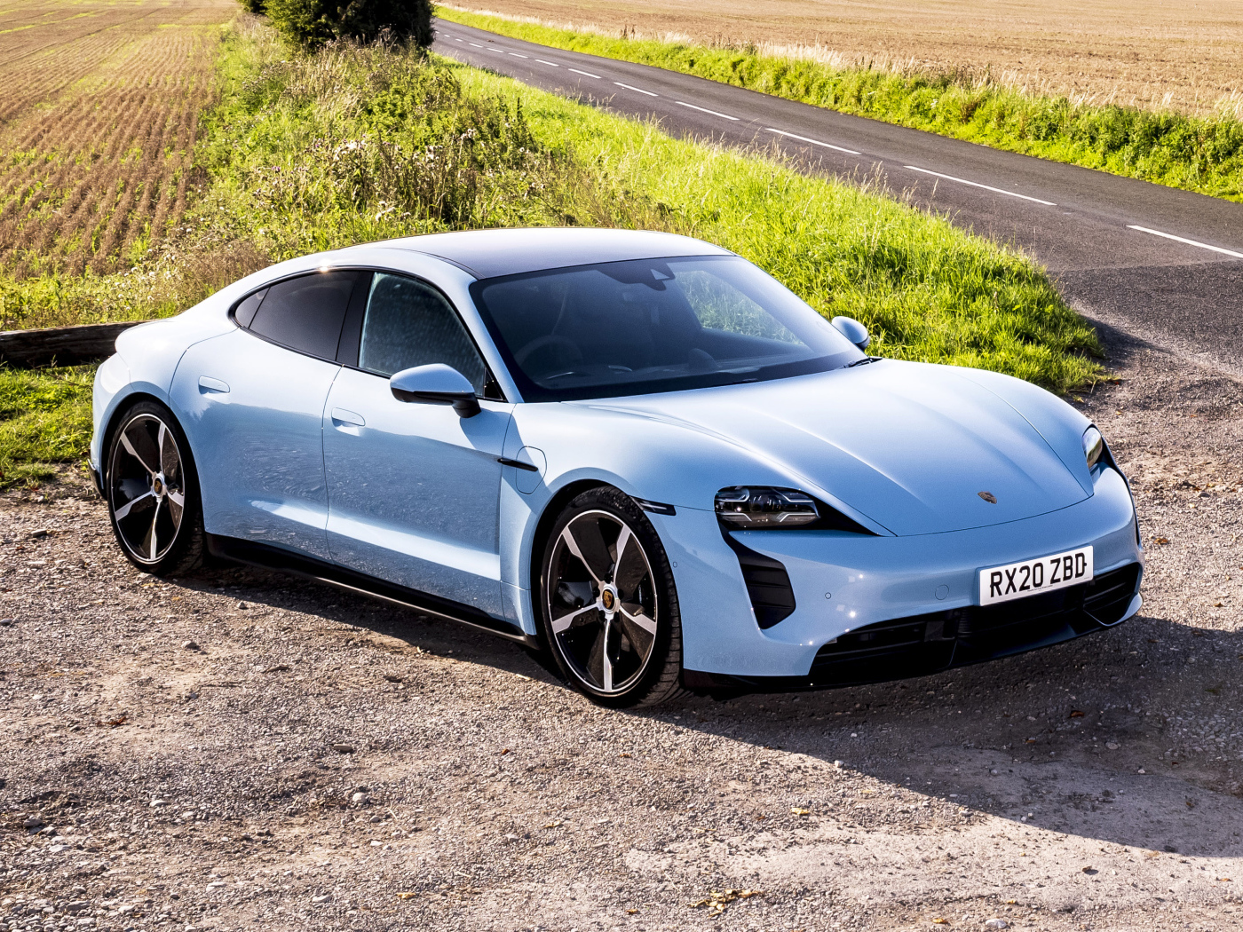 Быстрый автомобиль Porsche Taycan 4S 2021 года на фоне поля