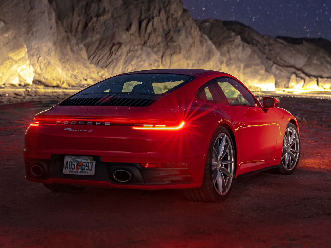 Красный автомобиль  Porsche 911 Carrera S, 2020 года в горах ночью 