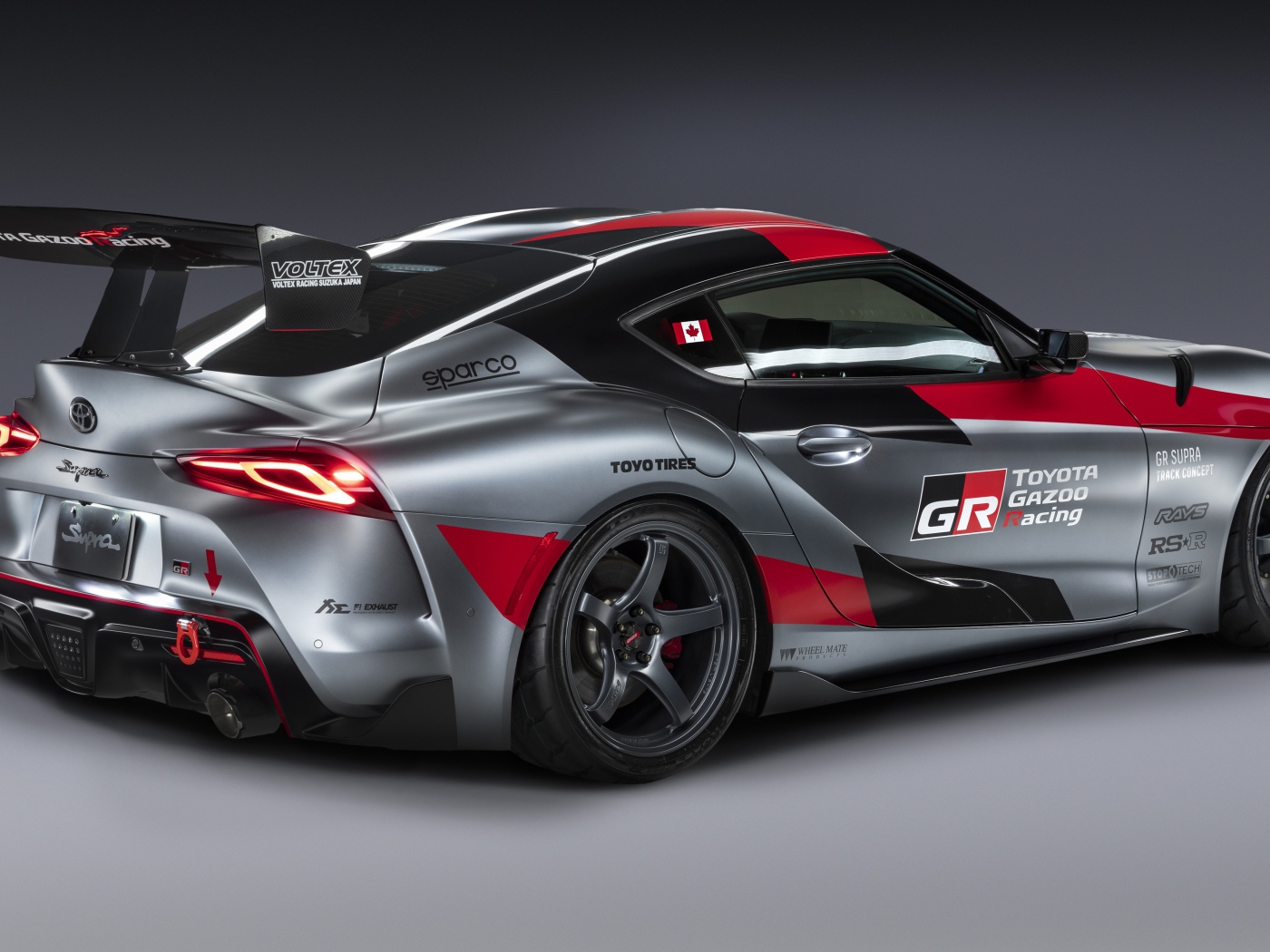 Спортивный автомобиль Toyota GR Supra Track Concept 2020 года вид сзади на сером фоне