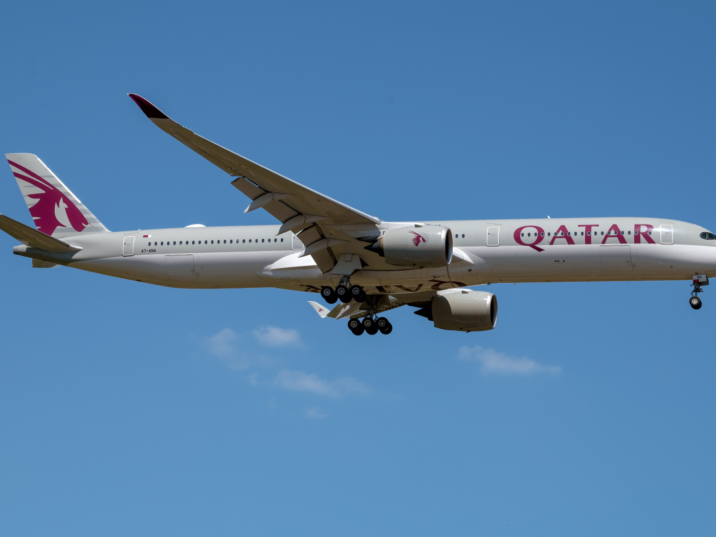 Пассажирский аэробус  A350-1000 авиакомпании Qatar в голубом небе 