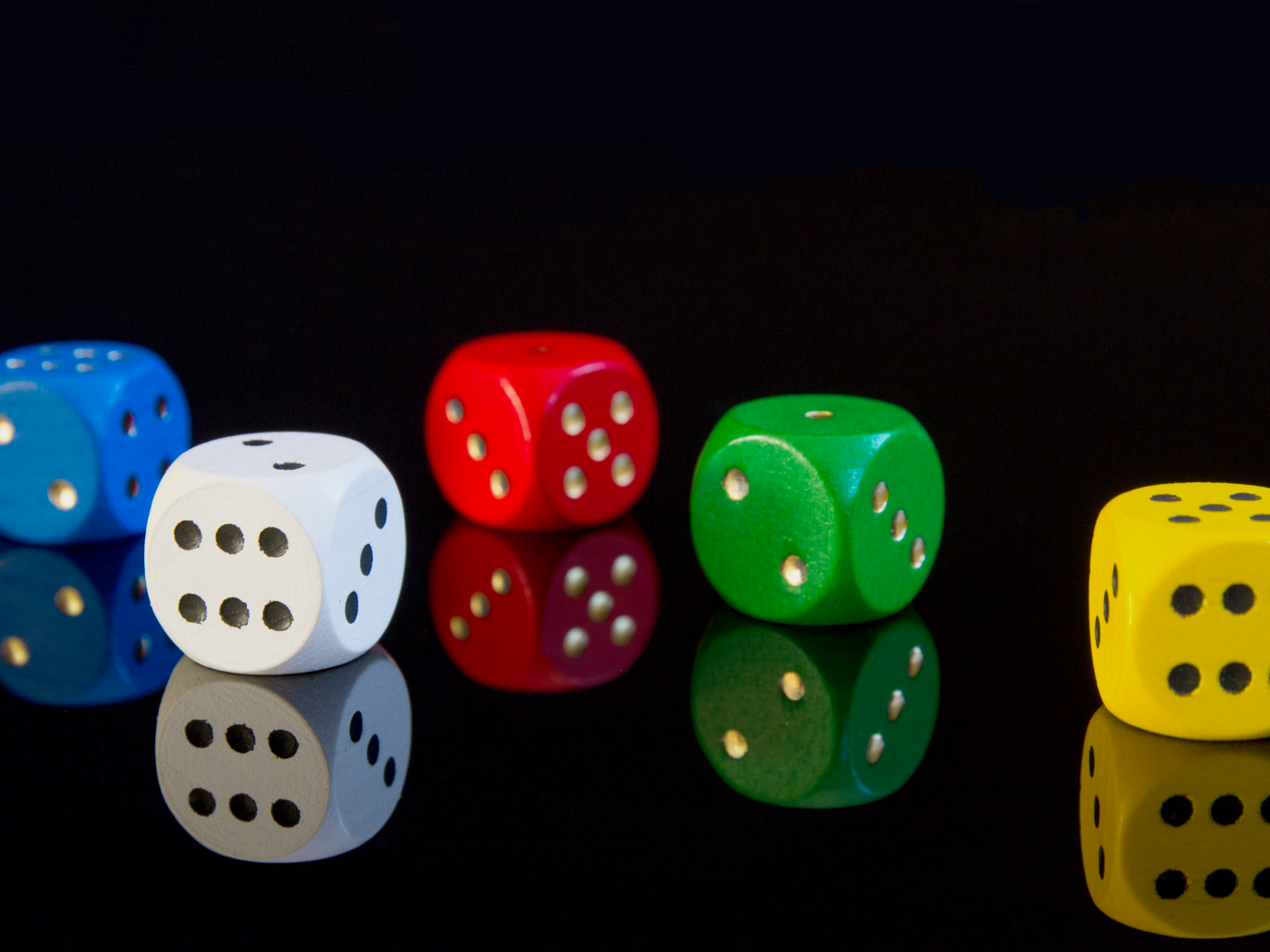 Разноцветные игральные кубики на черном фоне