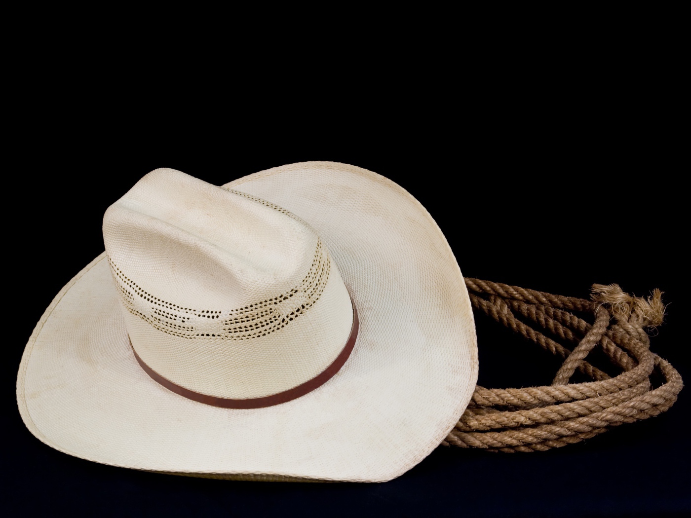 Белая ковбойская шляпа с лассо на черном фоне
