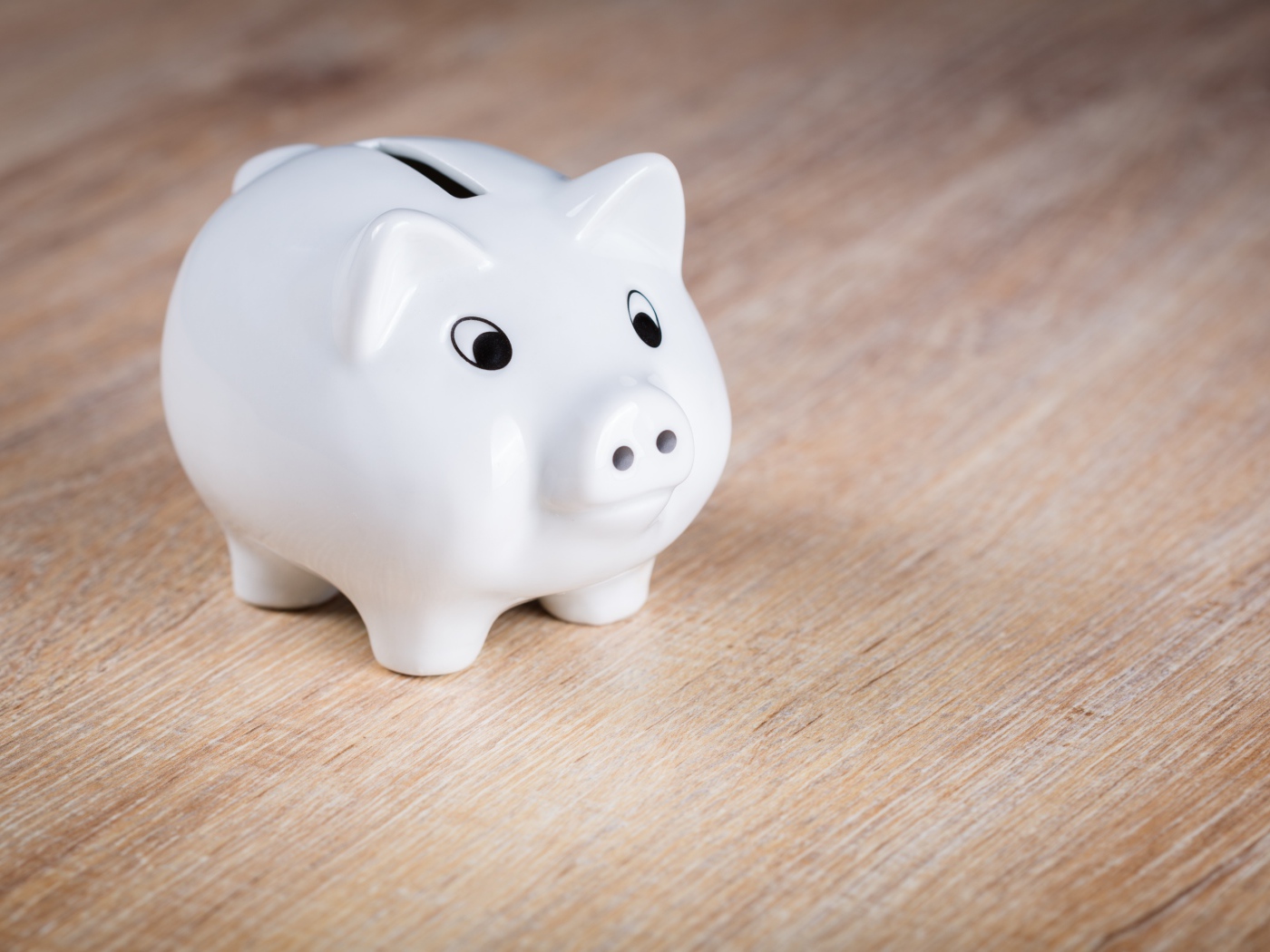 Белая свинья копилка на столе 