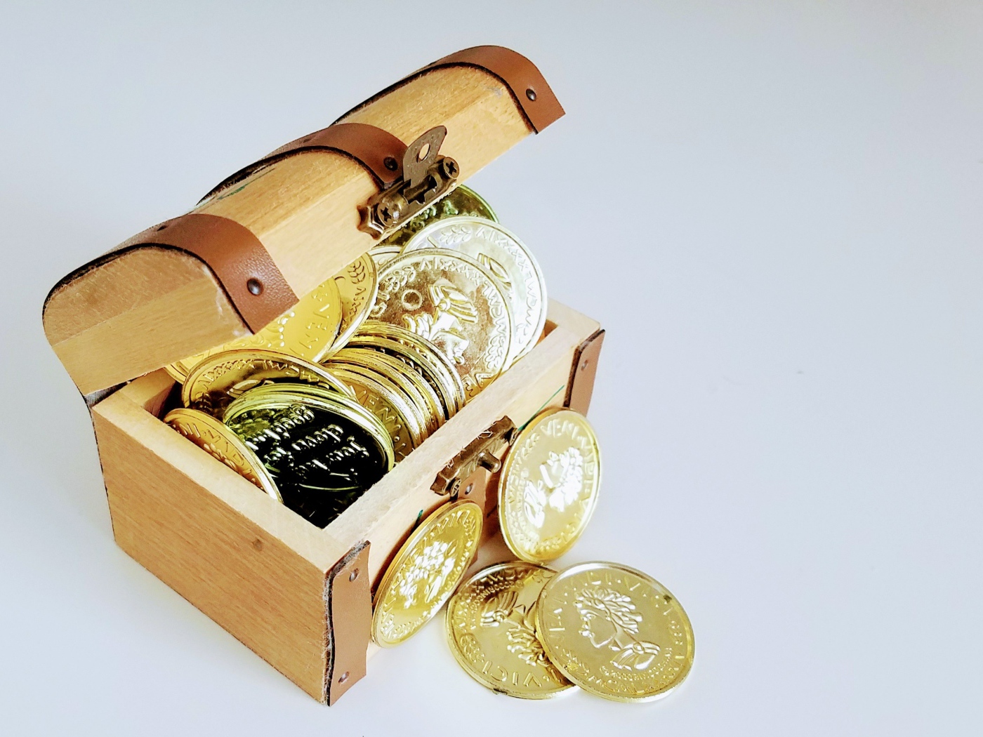 Золотые монеты в сундуке на сером фоне