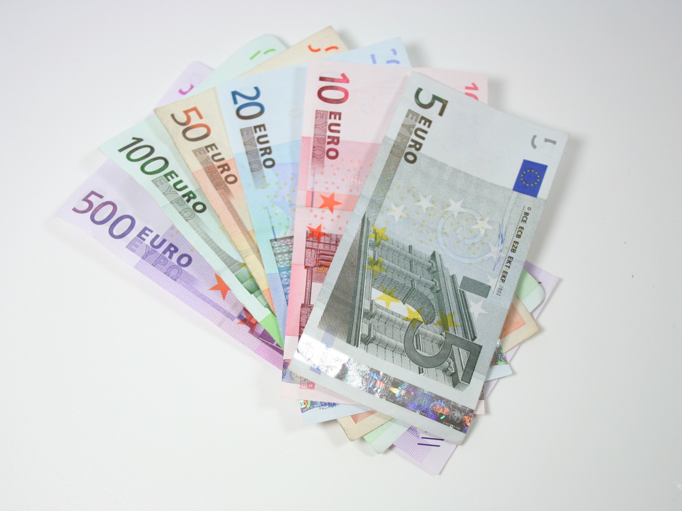Купюры евро разным номиналом на сером фоне