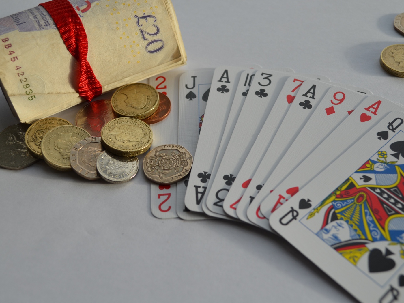 Деньги, монеты и колода карт на столе