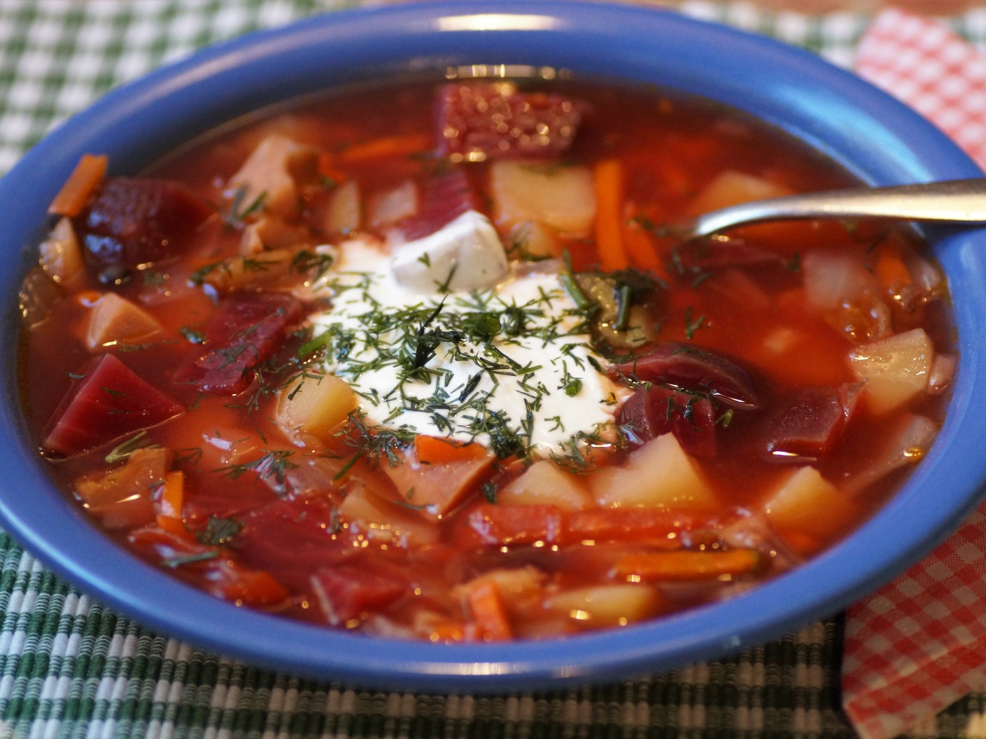 Borscht with sour cream in a blue bowl on the table