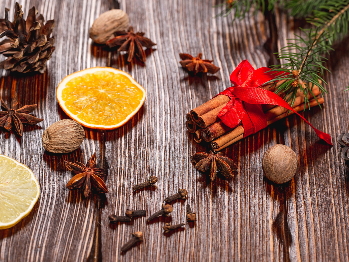 Корица на столе с орехами, бадьяном, сушеными апельсинами и гвоздикой
