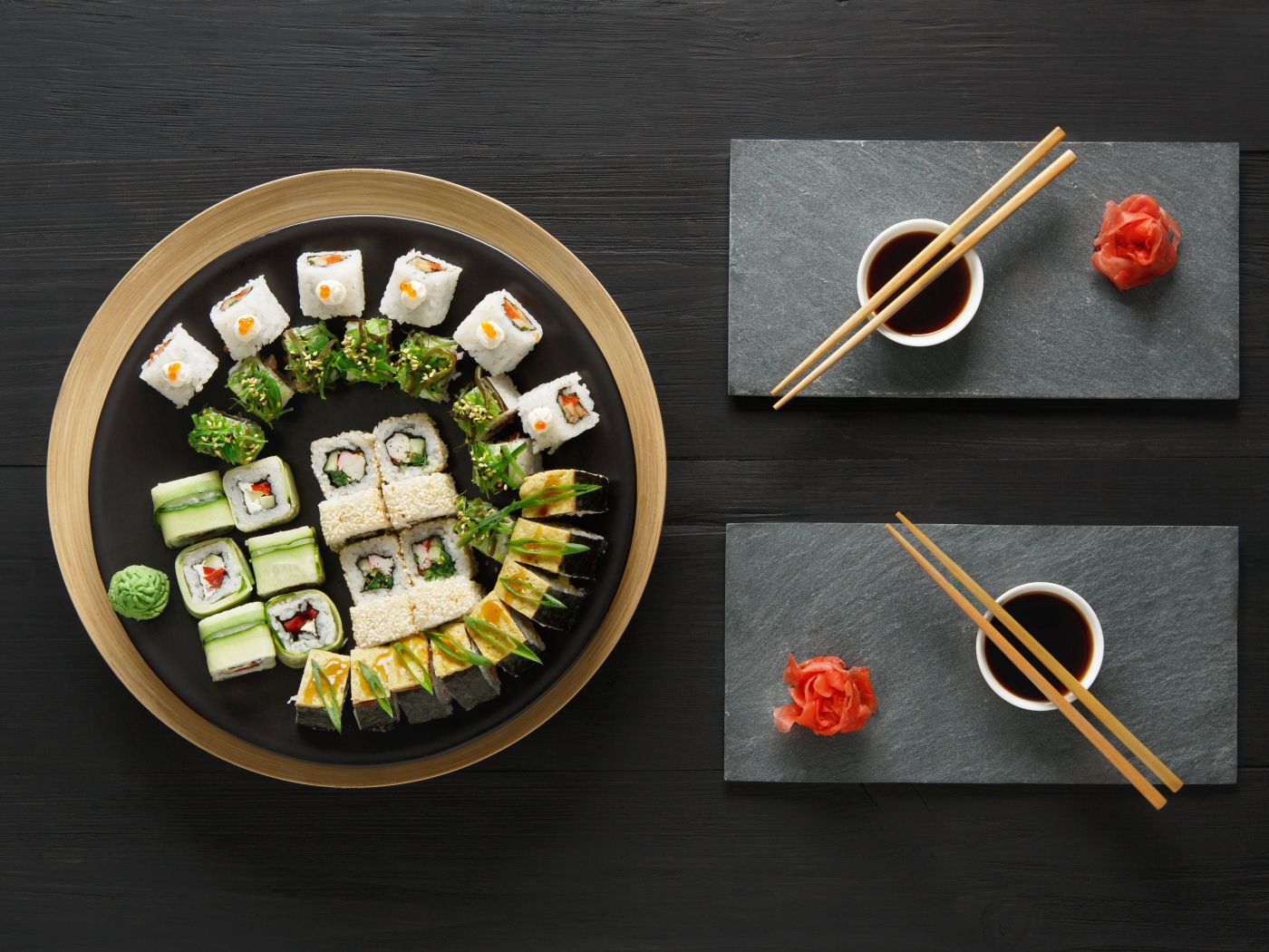 Вкусные  роллы на столе с соевым соусом и палочками 