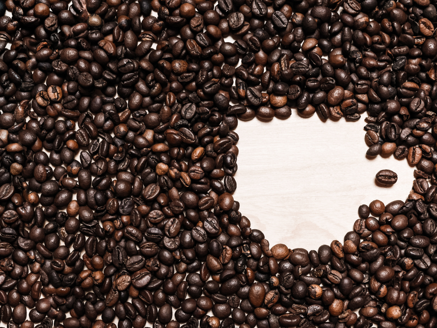 Рисунок чашки из кофейных зерен на столе