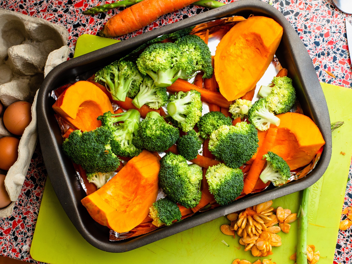 Свежие брокколи, морковь и тыква на противне 