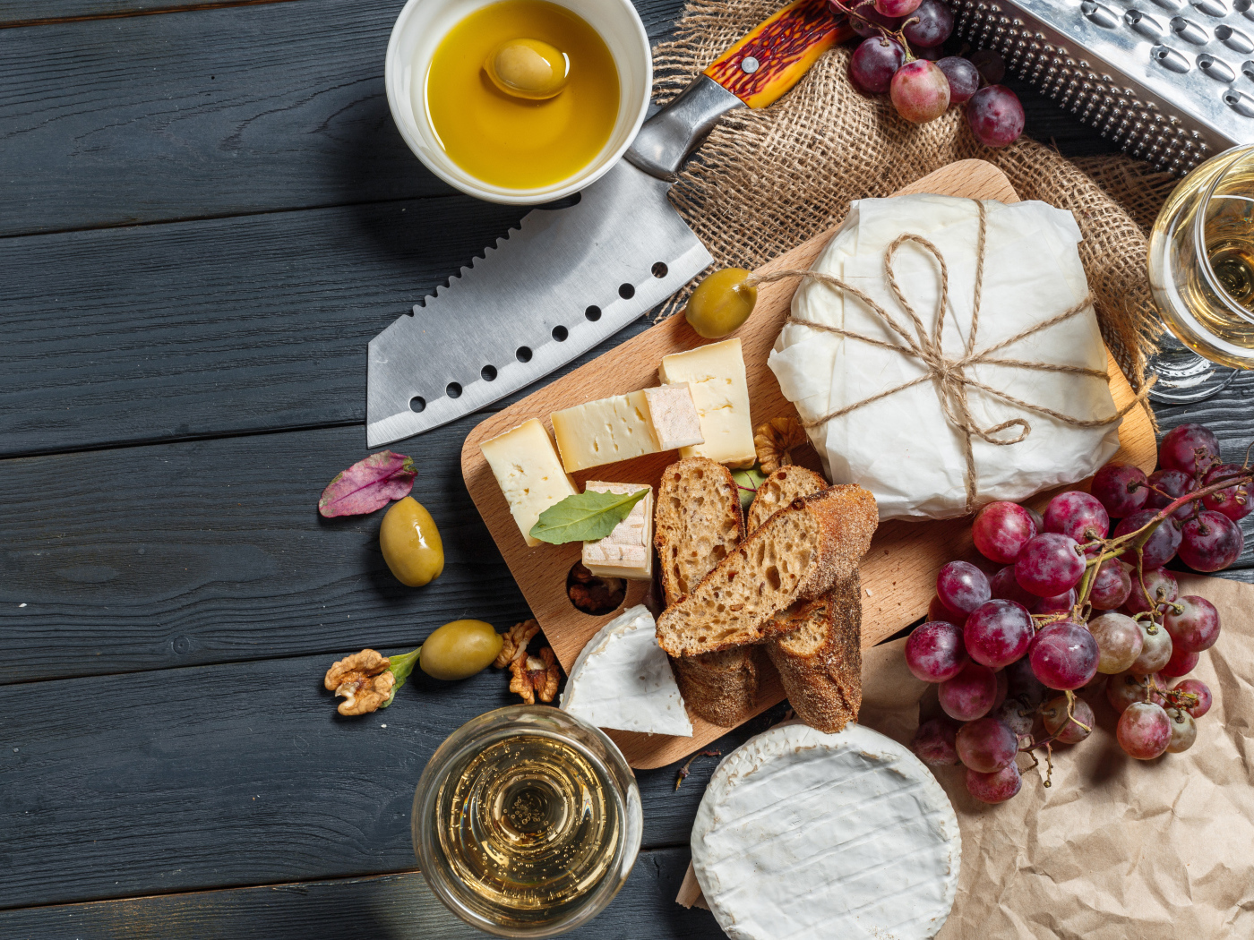 Виноград на столе с сыром, хлебом и оливками