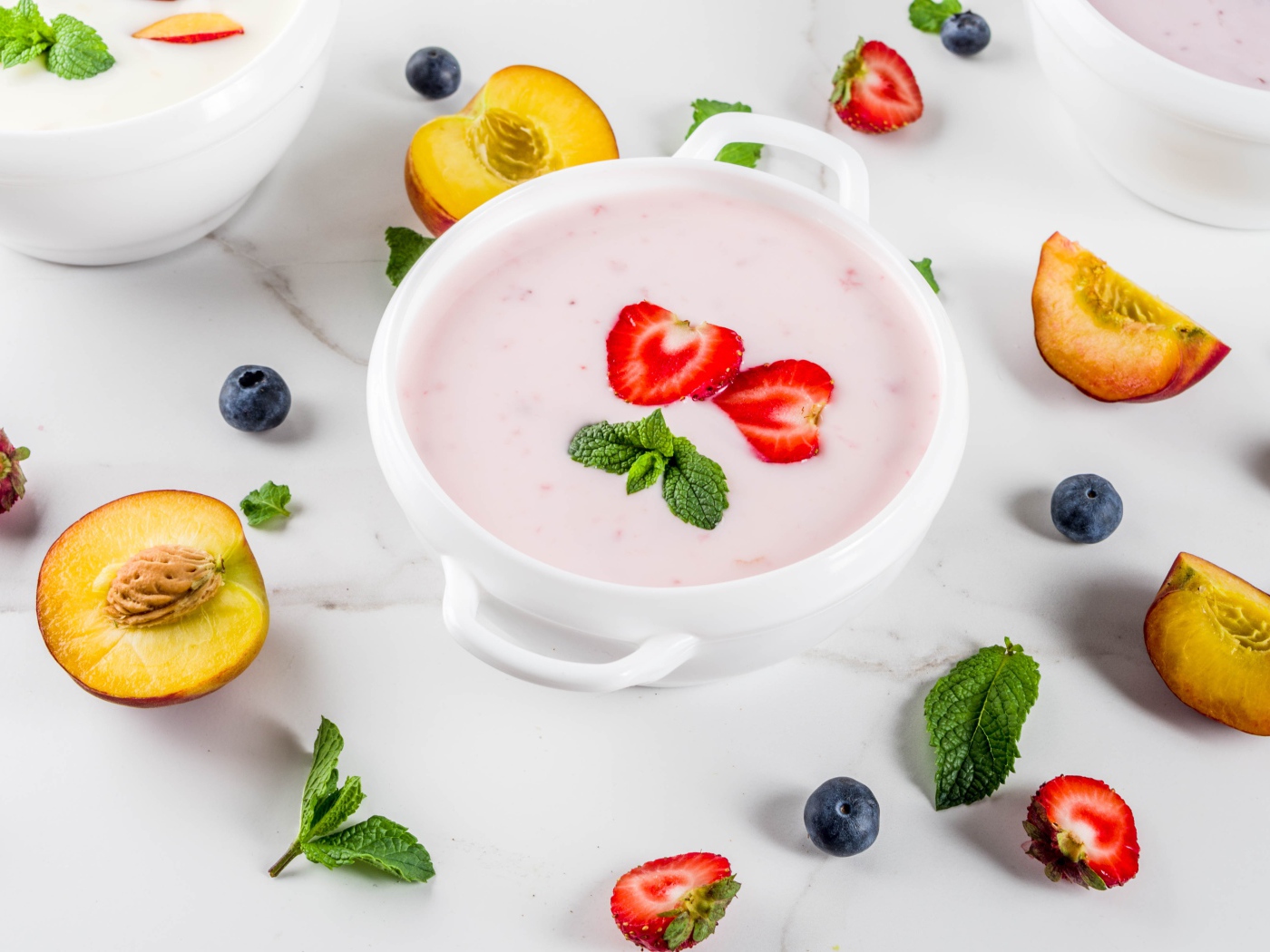 Молочный суп в тарелке на столе с ягодами и нектарином