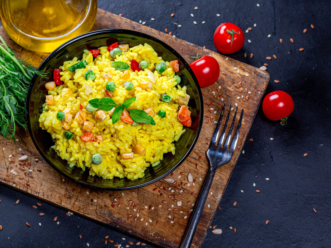 Rice with vegetables on a table with butter, herbs and tomatoes