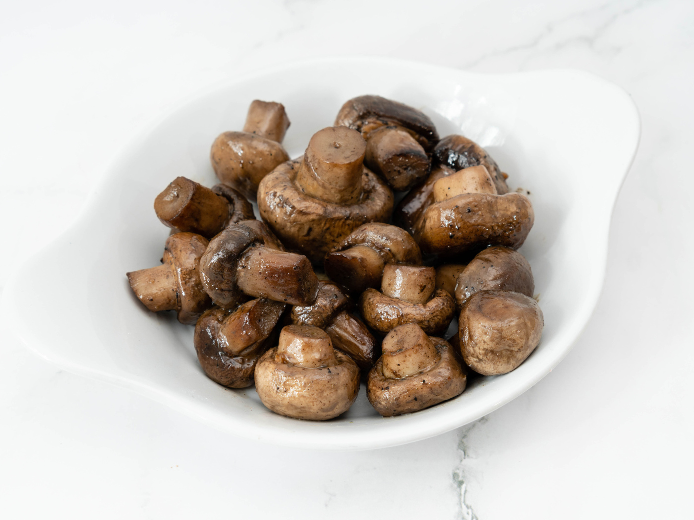 Жареные целые грибы шампиньоны на белом фоне