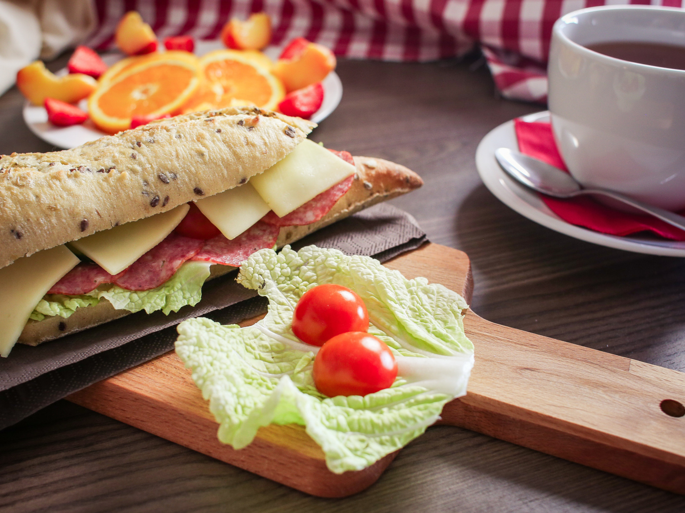 Бутерброды на столе с фруктами и чашкой чая