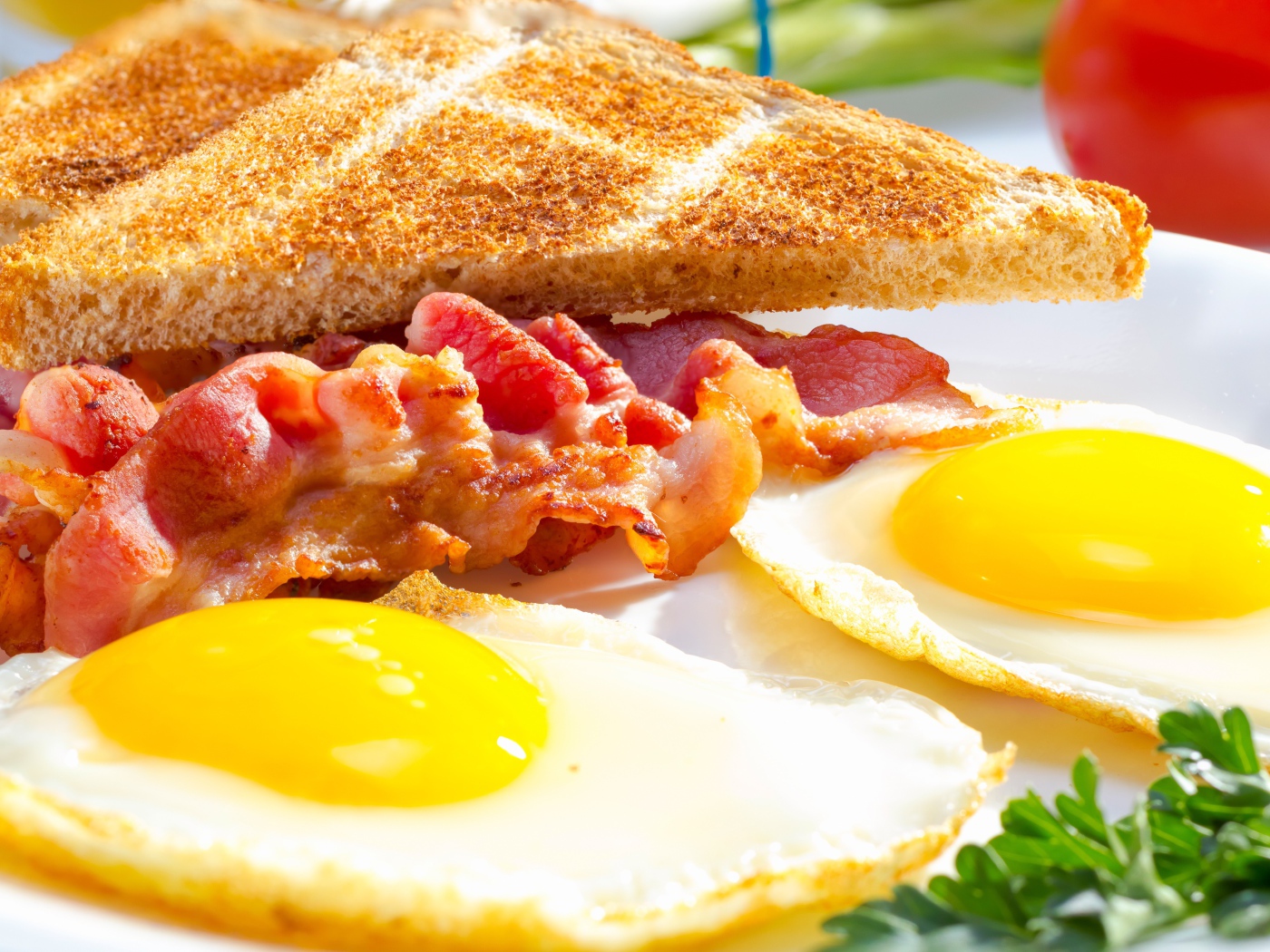 Яичница, бекон и гренки на завтрак на столе 