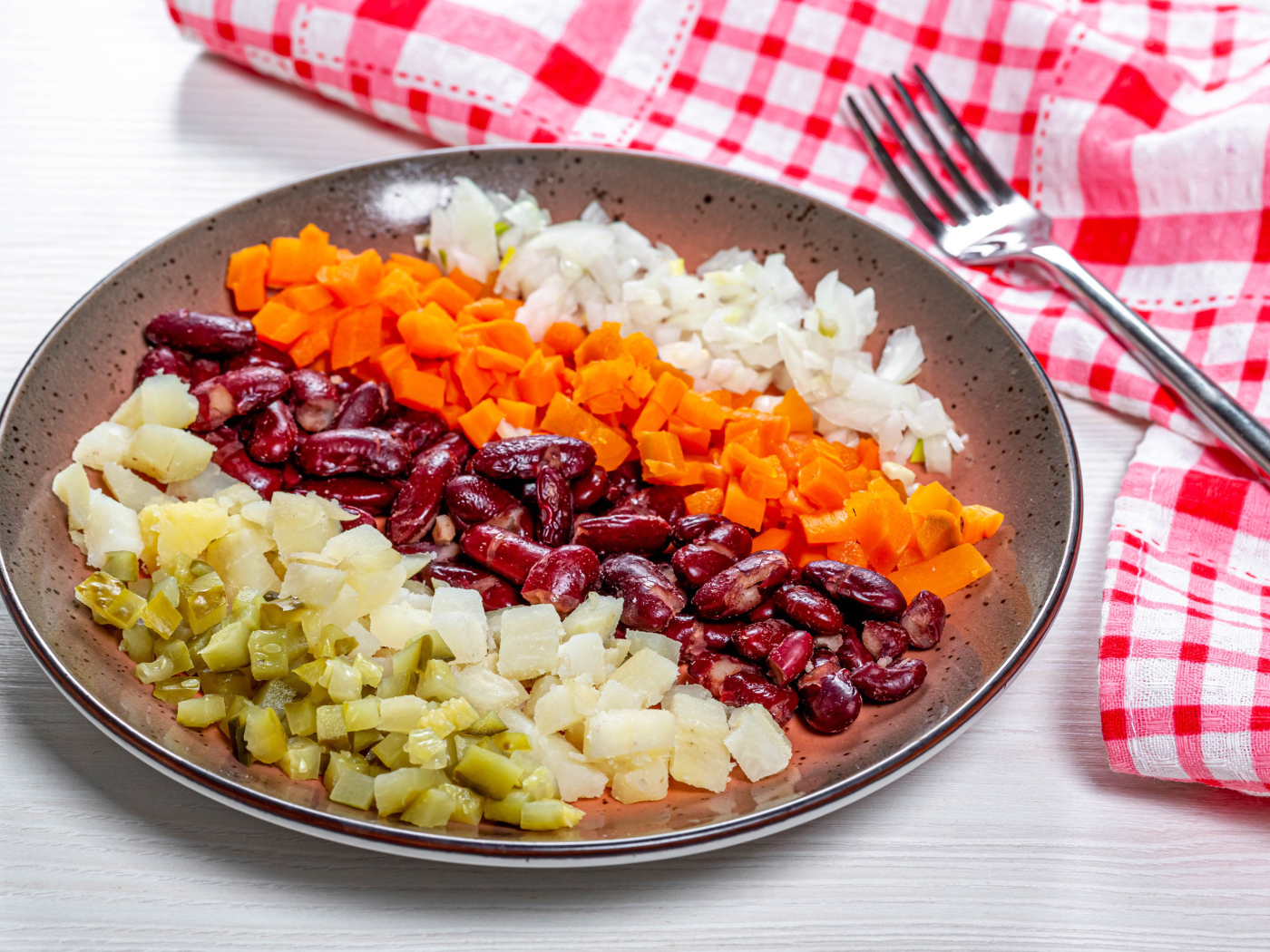 Овощи и фасоль нарезанные на тарелке 