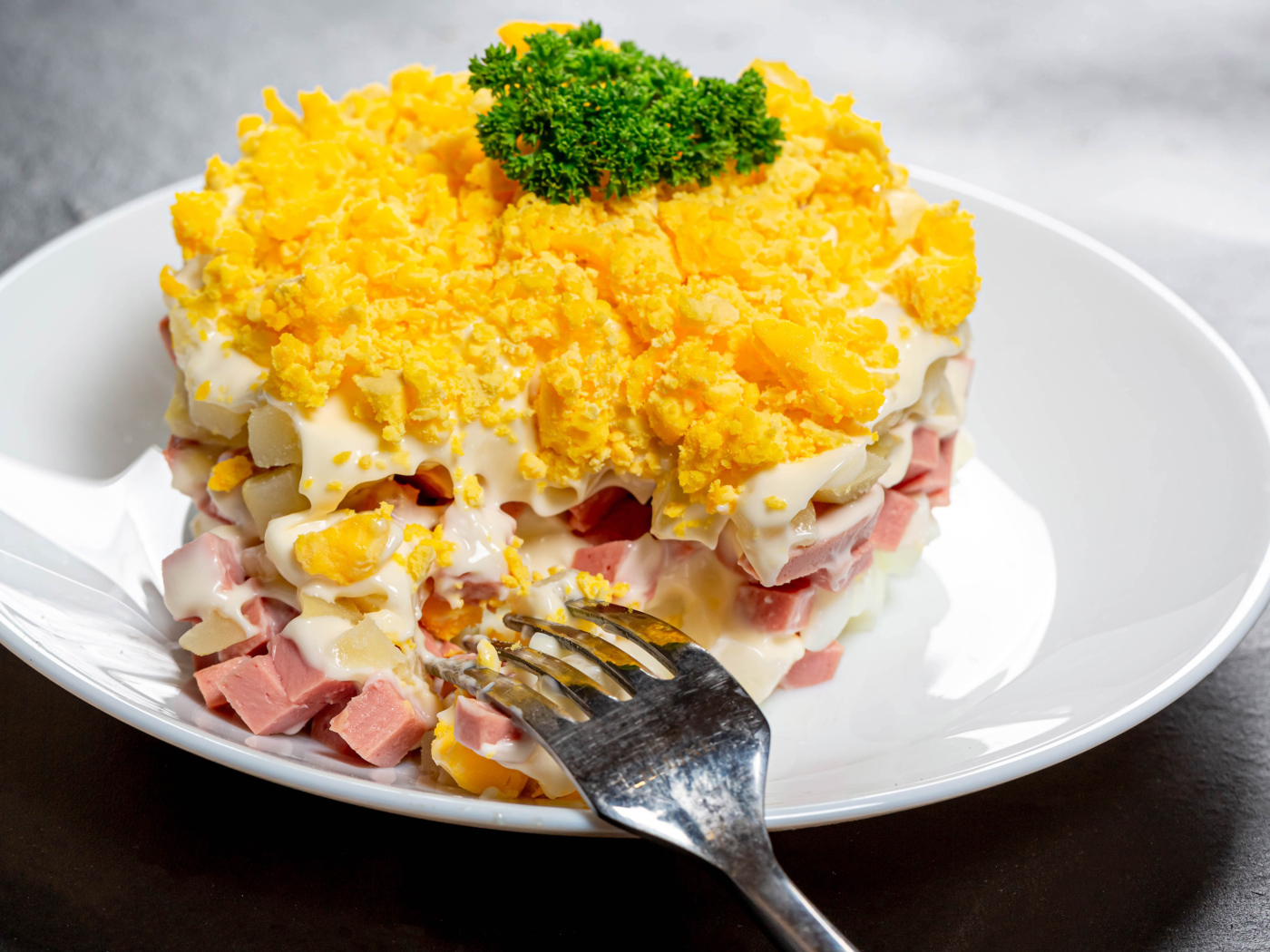 Вкусный салат на белой тарелке с вилкой