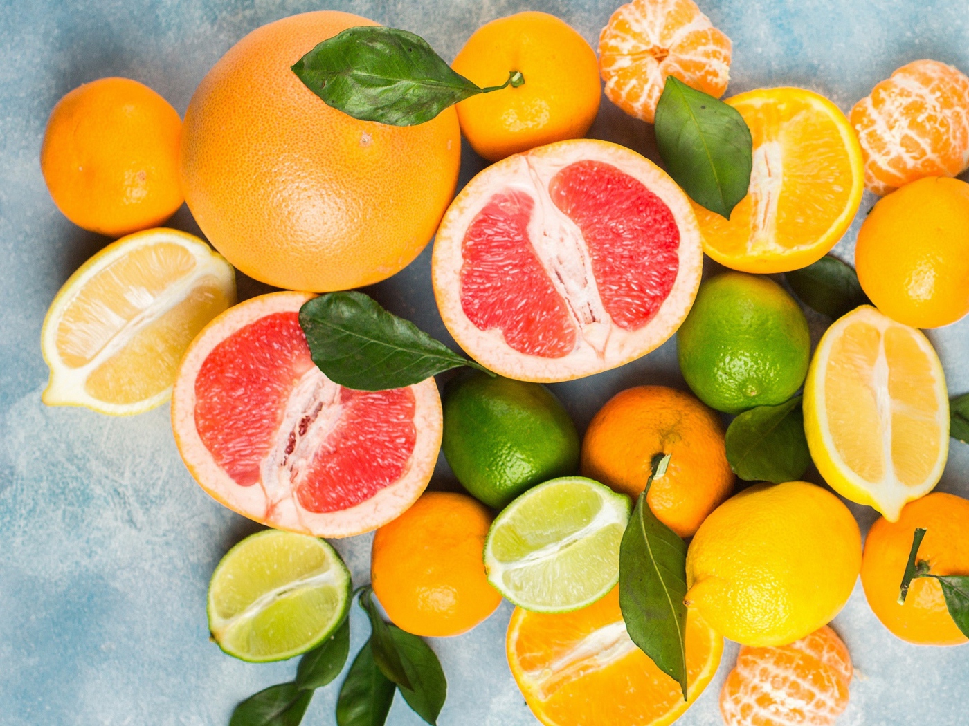 Аппетитные цитрусовые фрукты с зелеными листьями