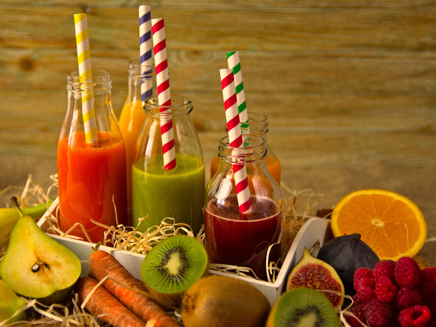 Бутылочки с соком на столе с фруктами 