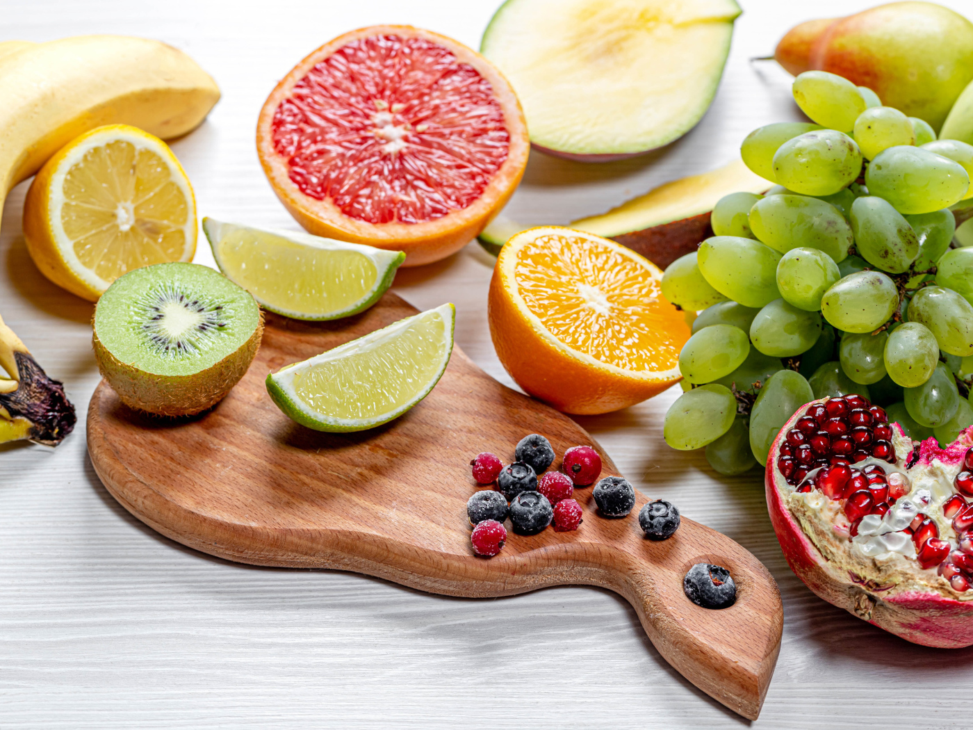 Вкусные цитрусовые фрукты и виноград на столе