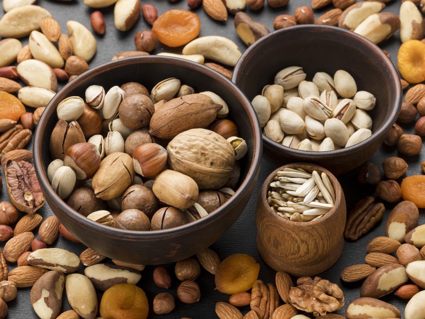 Разные виды орехов на столе в мисках 