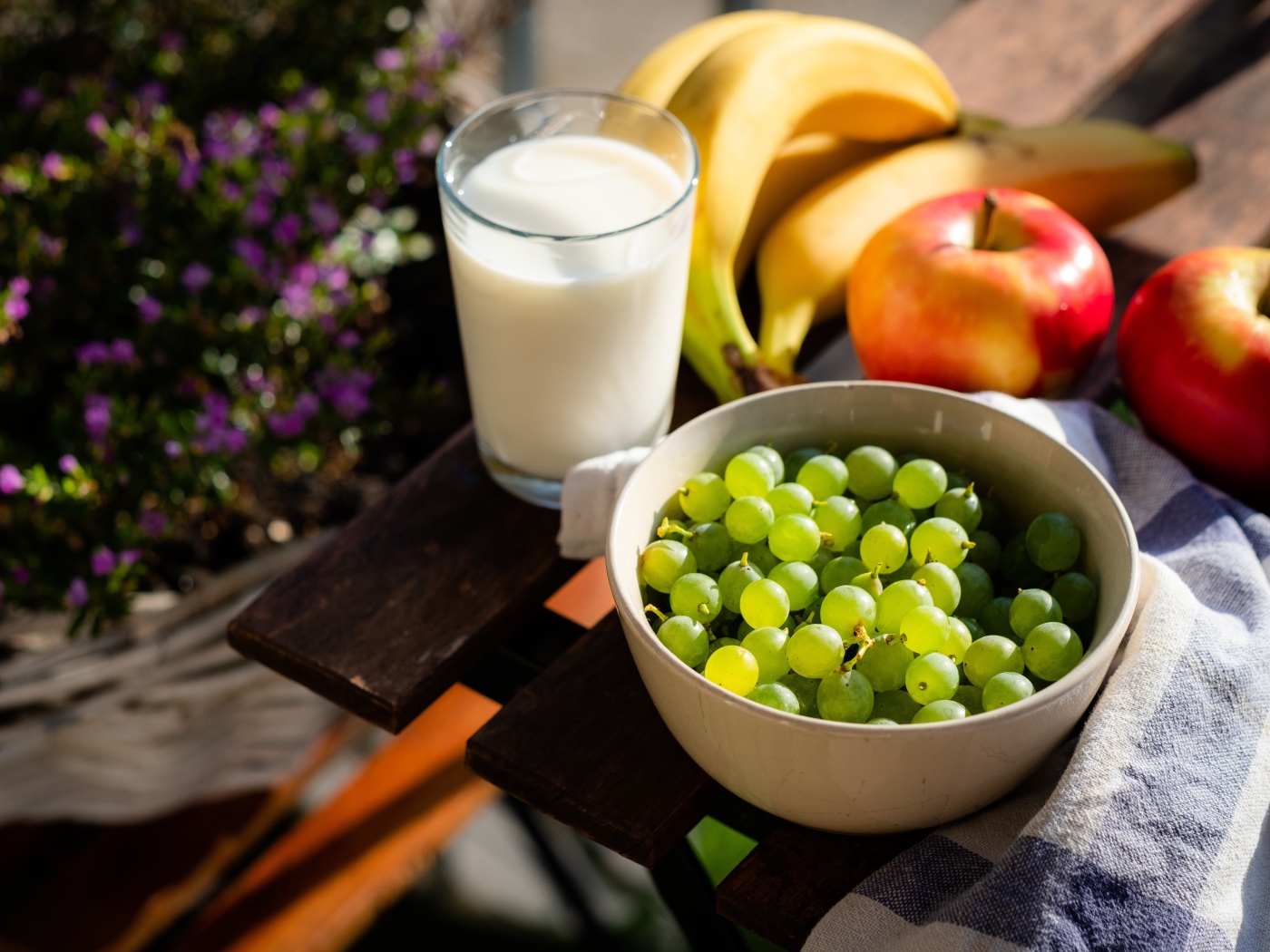 Green grapes on the table with bananas, apples and milk