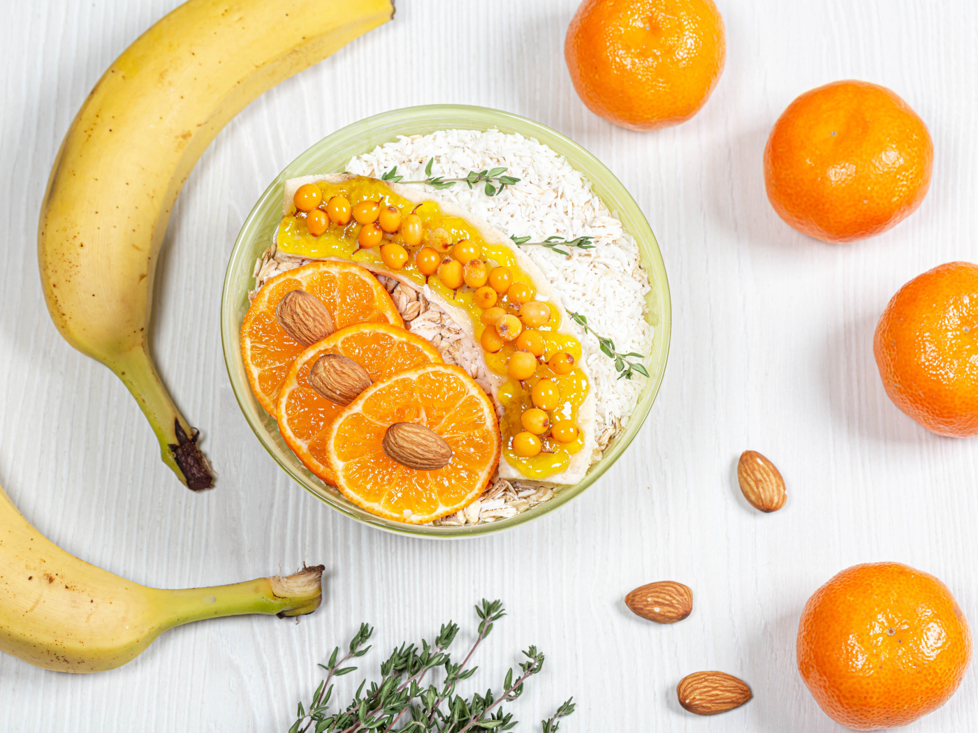 Мюсли с облепихой, бананом и апельсином на столе с фруктами