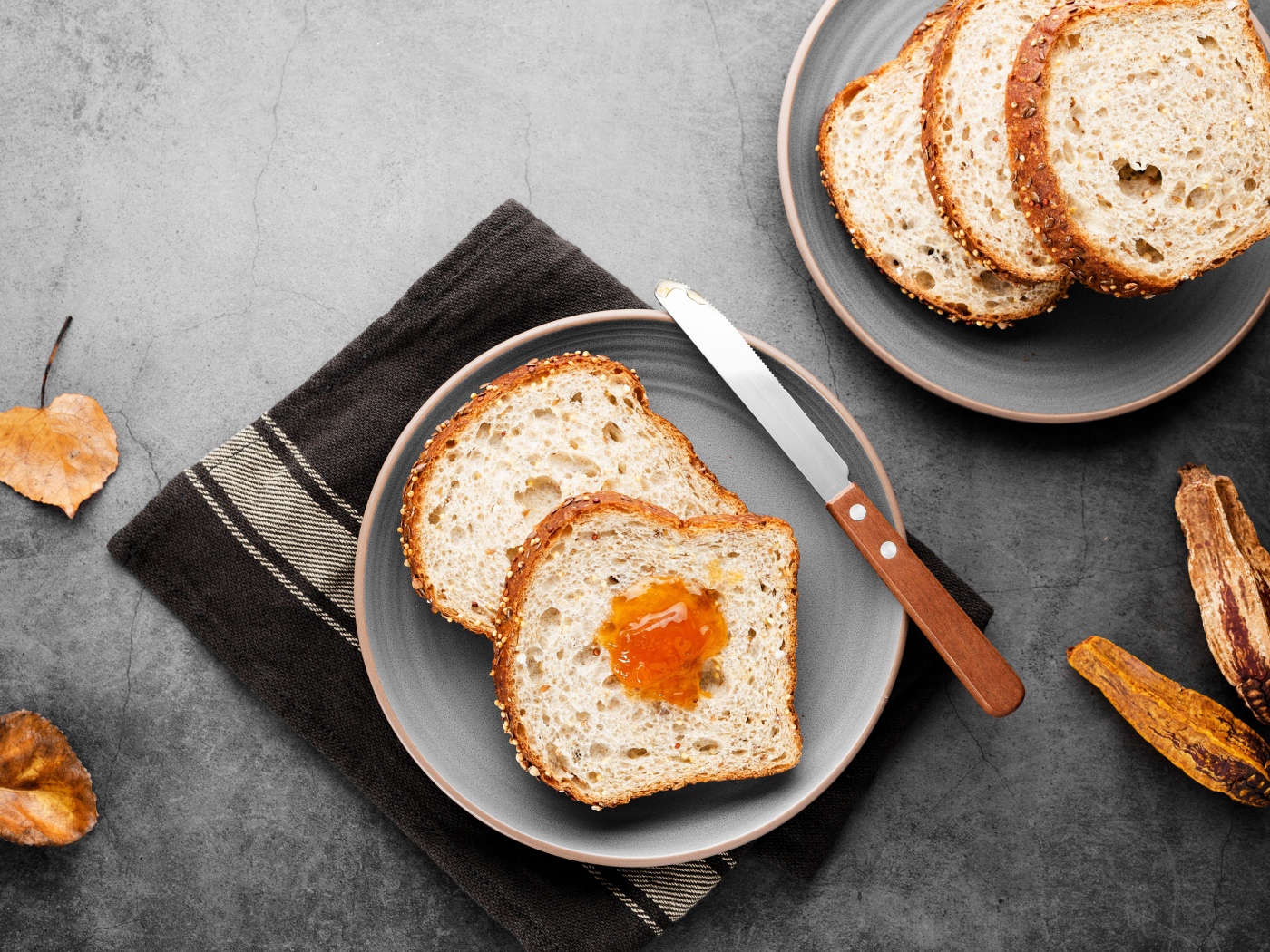 Куски хлеба с джемом на сером столе 