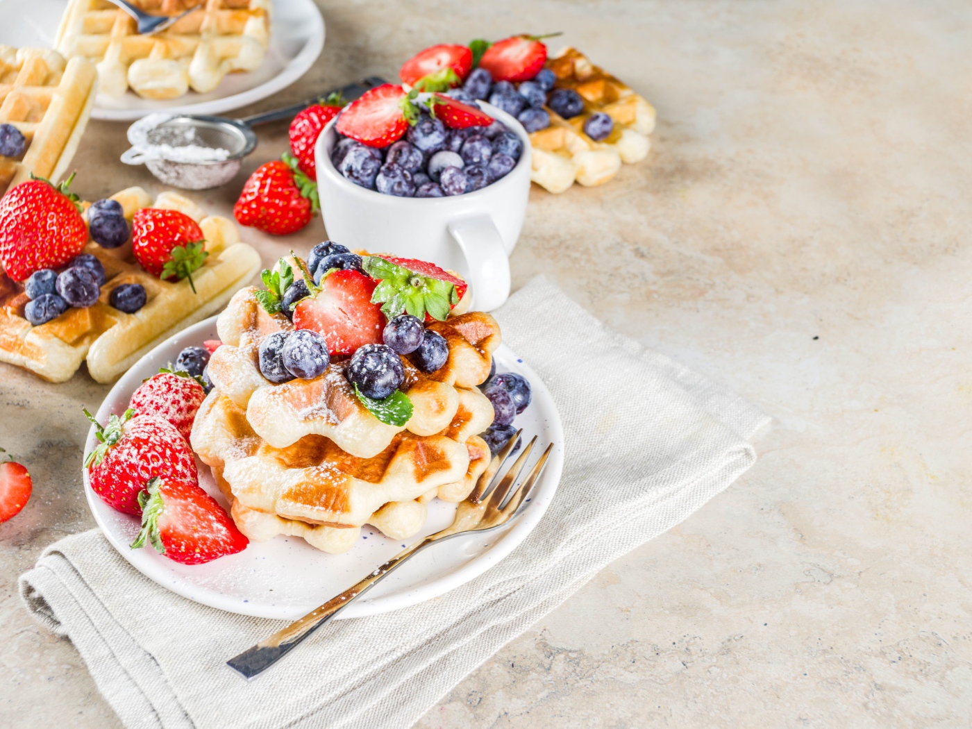 Tasty sweet waffles on a plate with berries and icing sugar