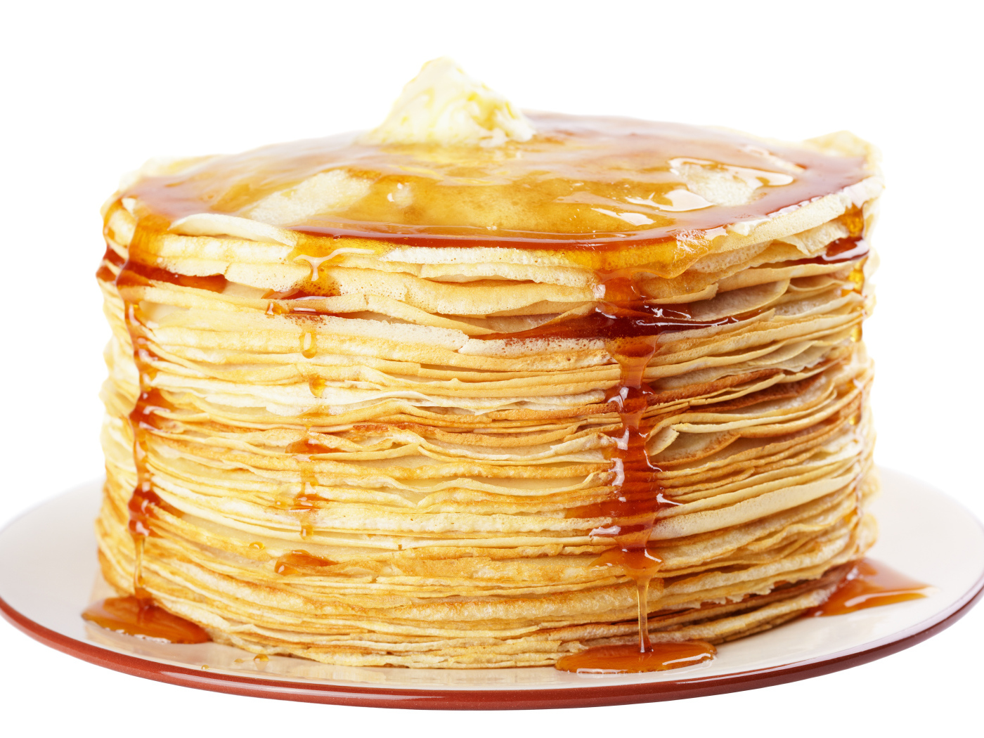 Тонкие блины с медом на тарелке на белом фоне