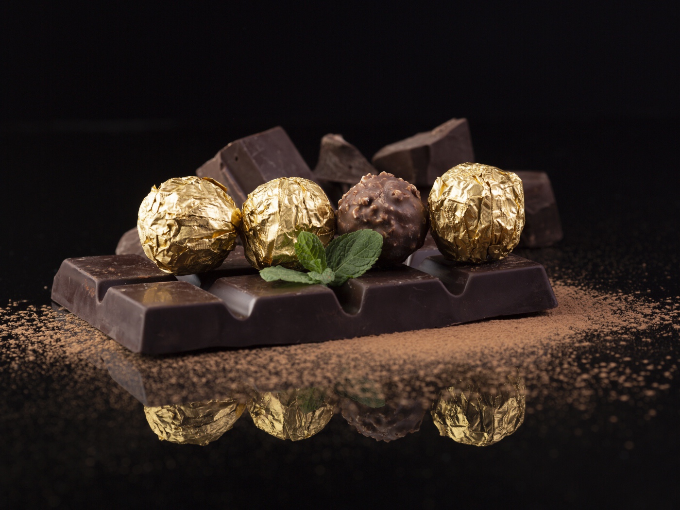 Плитки черного шоколада с конфетами на столе 