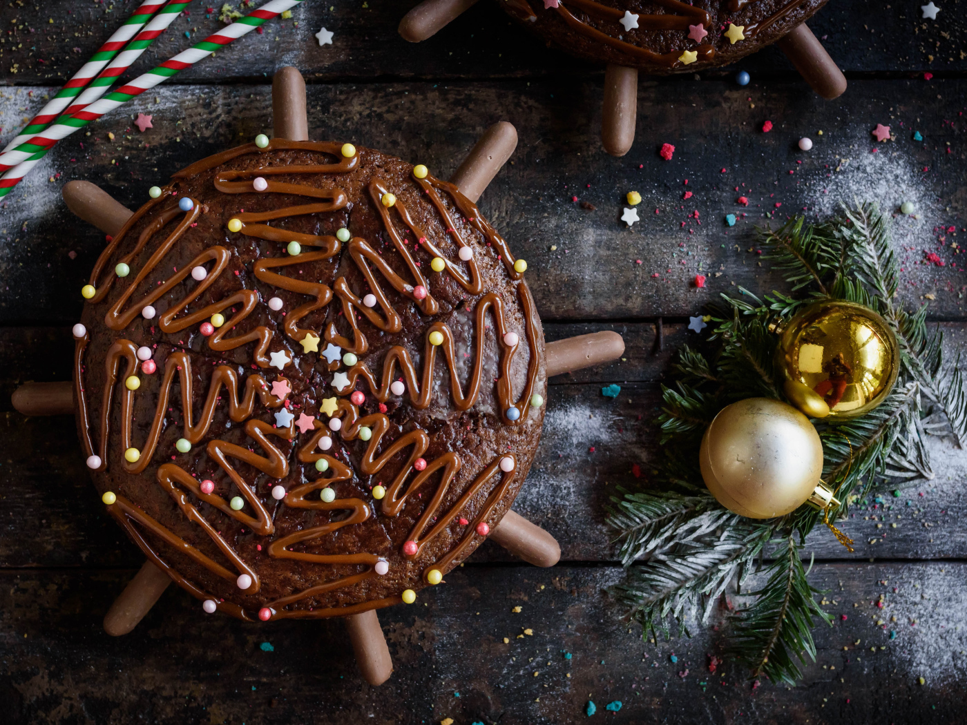 Шоколадное пирожное на столе с еловыми игрушками 