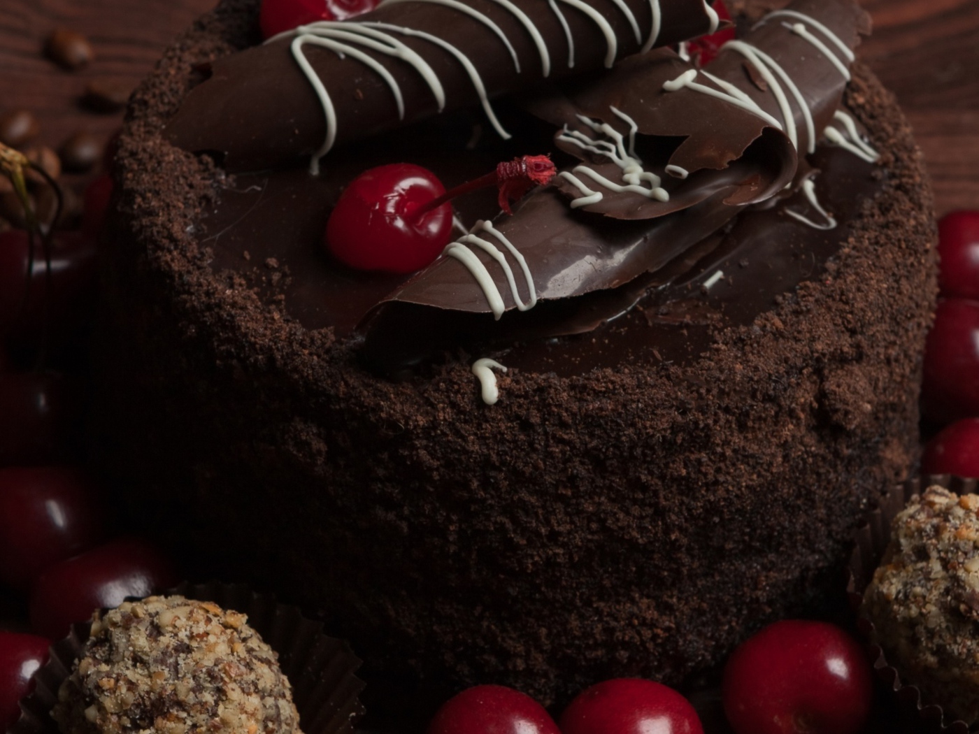 Шоколадный торт с конфетами и вишней на столе 