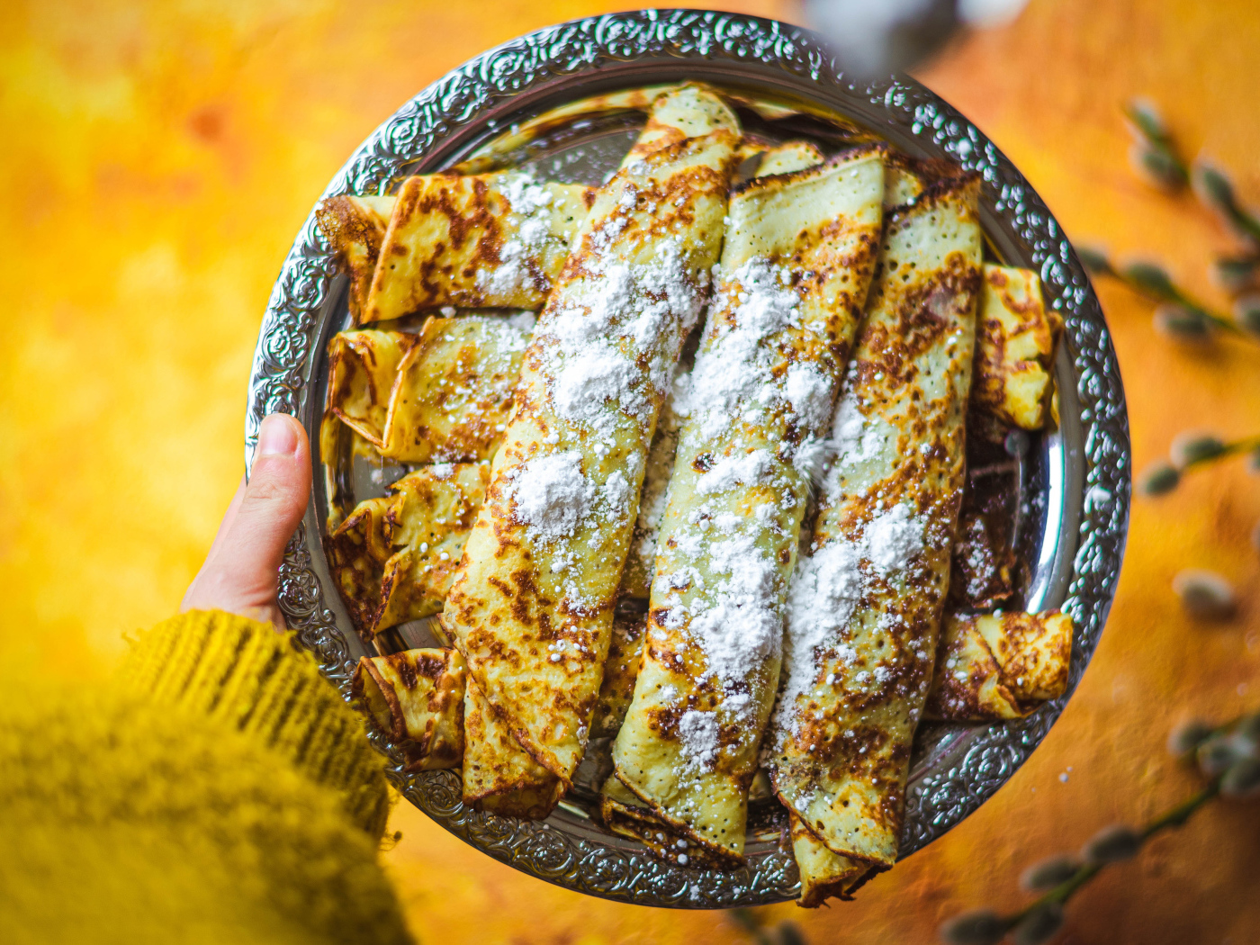 Вкусные тонкие блины с сахарной пудрой на блюде