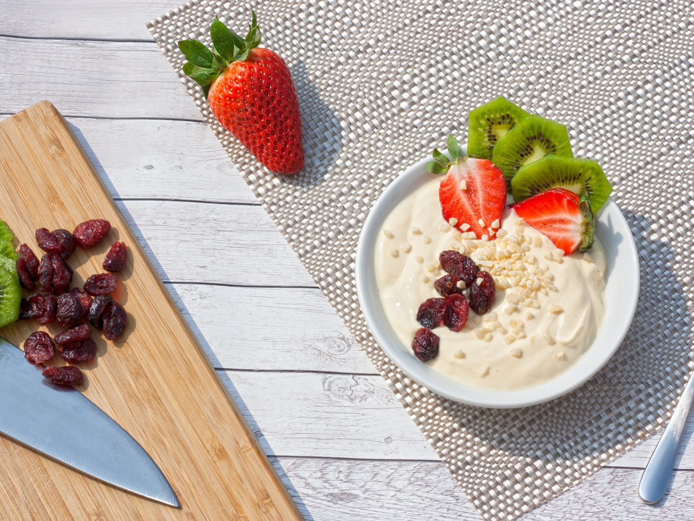 Десерт на столе с клубникой, киви и сушеной вишней