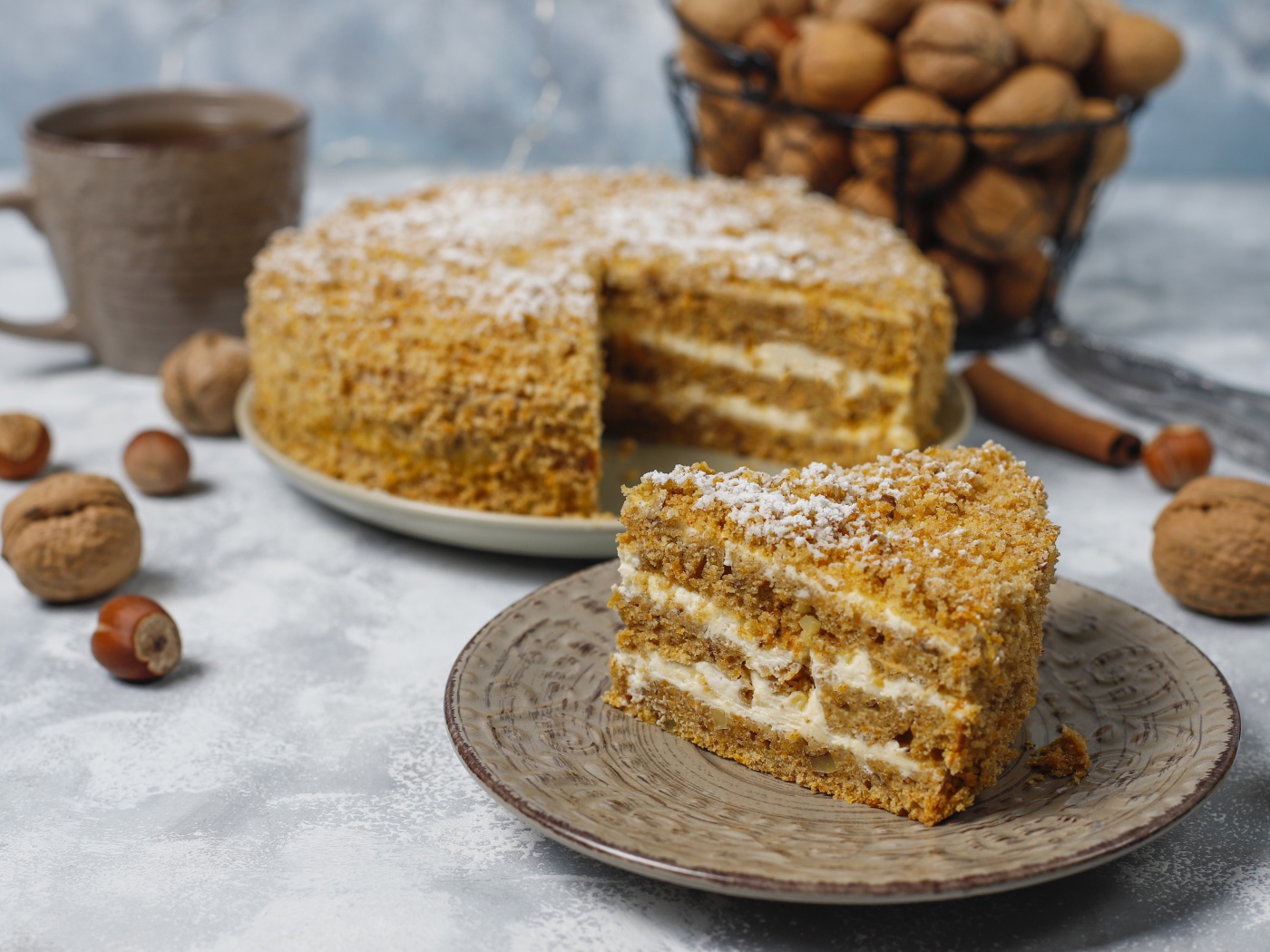 Торт медовик на столе с орехами и чашкой кофе