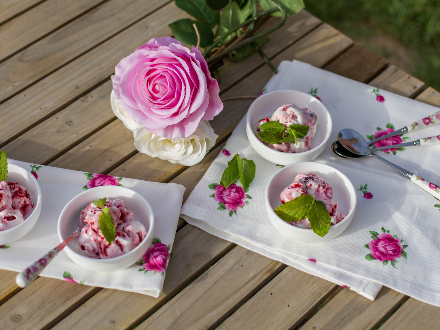 Ice cream on a table with a pink rose