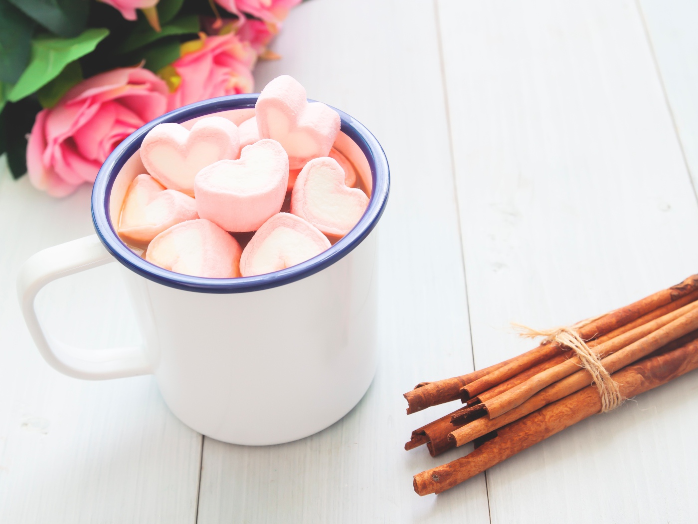 Железная чашка какао с маршмеллоу на столе с корицей 