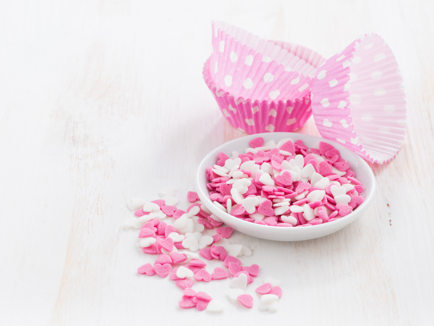 Маленькие белые и розовые сердечки на столе 