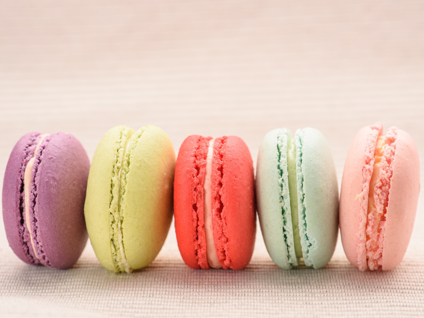 Разноцветное печенье макарон на розовом фоне 