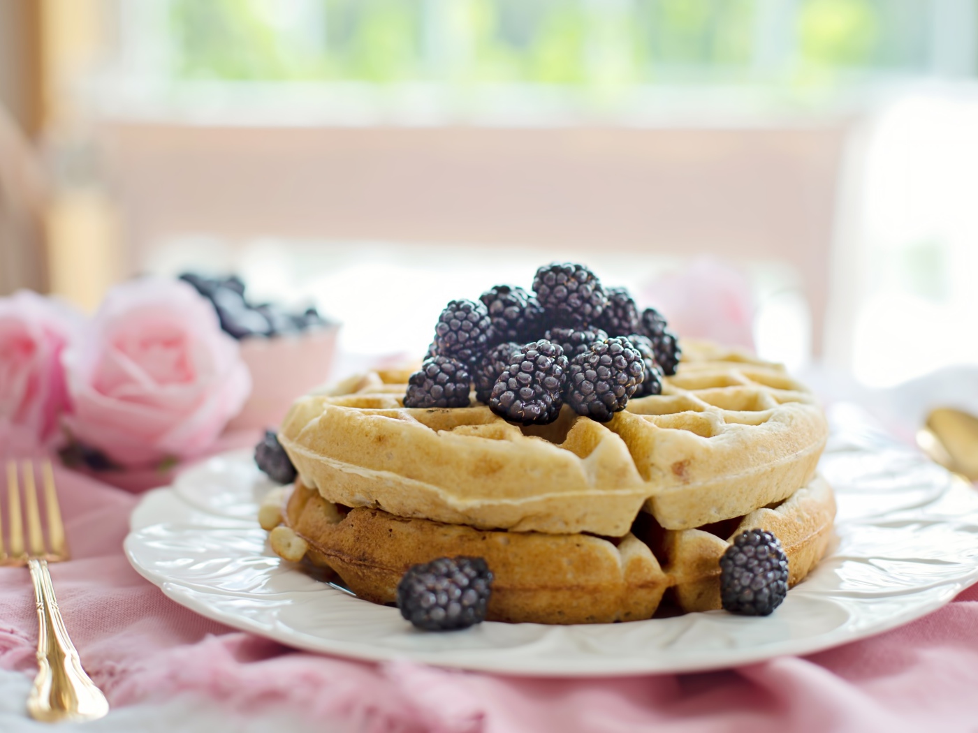 Сладкие вафли на тарелке с ягодами черники 